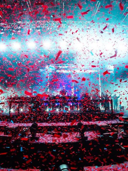 A storm of red and blue confetti creates a chaotic and beautiful moment during Armin van Buuren's high-energy performance.