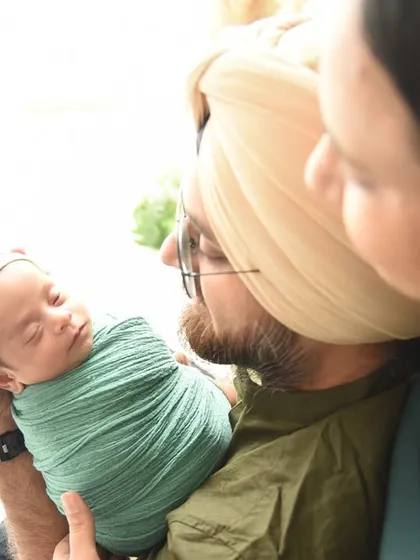 A close-up shot focusing on the father's loving gaze as he holds his newborn. This intimate perspective highlights the powerful bond between a parent and their new child.
