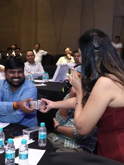 Presenting an award to a happy guest. Recognizing and rewarding audience members, whether for games or participation, is a simple way to make a corporate event more personal and memorable.