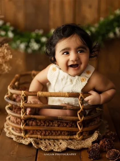 The pure, uncontainable giggle of a baby during her sitter session. This shot, set against a rustic wooden backdrop, captures the joyful personality that blossoms in a child's first year.