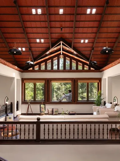 High above the main living area in the Dream Coffee Estate, this mezzanine lounge is a sanctuary in the sky. The soaring terracotta-tiled roof with integrated glass skylights, framed by hand-turned wooden balustrades, creates a serene space that feels both expansive and intimately connected to the forest canopy outside.