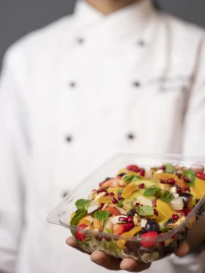 A chef's presentation of our Fruit Salad Bowl. It's a super healthy and delicious combination of exotic fruits, nuts, and a light yogurt dressing.