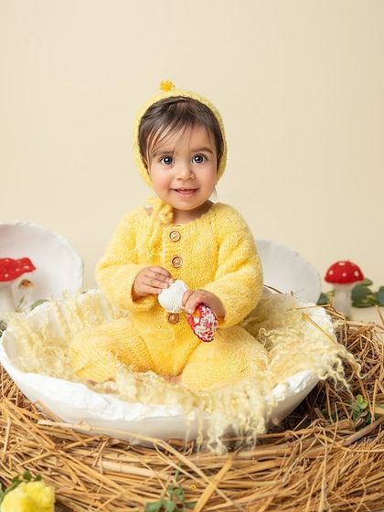 A perfect portrait of a happy baby in her nest. The soft lighting and her sweet expression make this a truly timeless and heartwarming image.