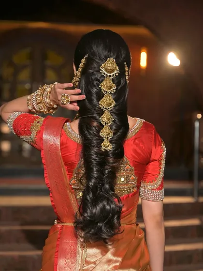 It's all in the details. This traditional South Indian bridal hairstyle features a long, thick braid beautifully decorated with classic temple-style hair jewellery, completing the opulent look.