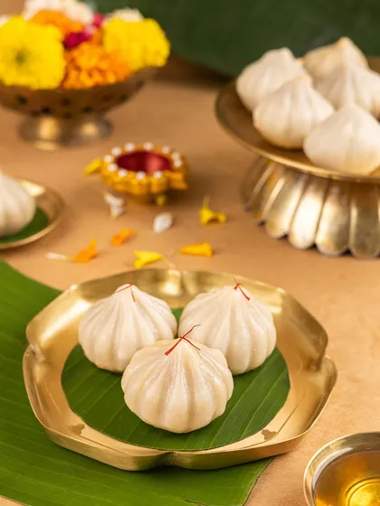 Classic steamed modaks, garnished with saffron. I styled this shot with a banana leaf and a brass plate for a simple, clean, and traditional look that focuses on the purity of the sweet.