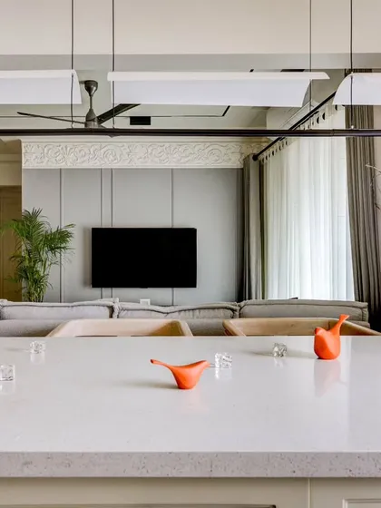 A view from the kitchen's breakfast counter towards the living room. The open-plan design allows for a seamless flow and connection between the culinary and relaxation zones.