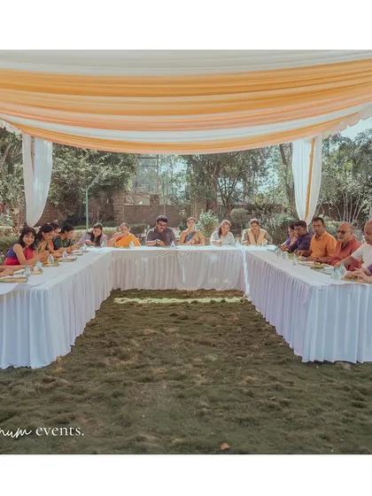 An intimate U-shaped seating arrangement for the family lunch, set up on the lawn under a simple draped canopy.