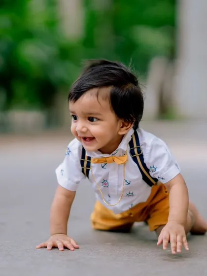 The pure joy of childhood in one photo. This candid shot captures a happy little boy on the move, with a smile that lights up the entire frame.