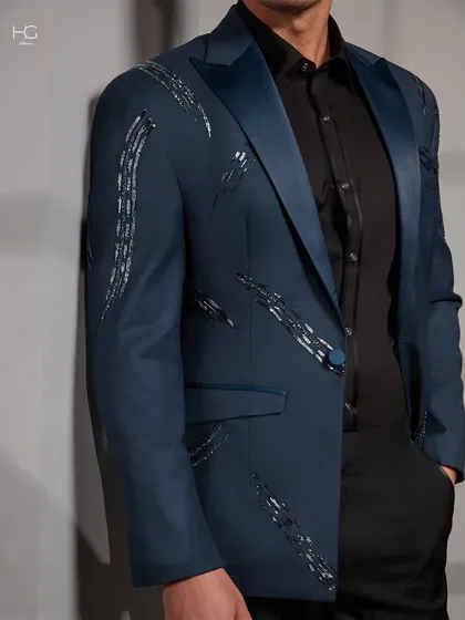 A closer look at the embroidered blue cocktail jacket, showing the texture of the fabric and the way the satin lapel catches the light.