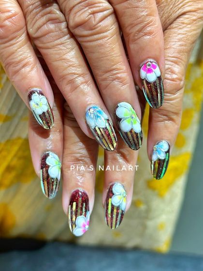 This intricate design requires a lot of layering to achieve. It combines a glittery, striped base with multi-colored, hand-painted flowers.