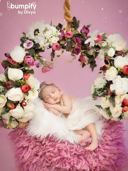 Another perspective of the magical floral swing, showing the baby sleeping peacefully while seemingly floating in a cloud of flowers.