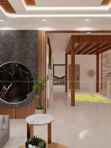An open-concept living and dining area in a modern Bangalore villa. The design features a striking black marble art piece, wooden rafters, and a seamless flow into the rest of the home.