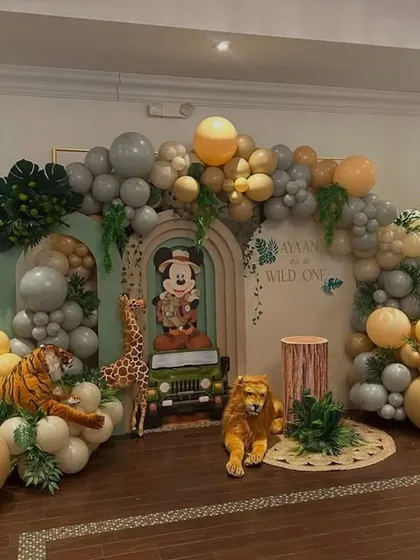 I bring magical worlds to life, like this "Wild One" safari adventure featuring Mickey Mouse. This large-scale backdrop combines custom cutouts, lush balloon garlands, and themed props to create an immersive experience for a child's special day.