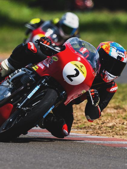 A rider leans into a corner during the Royal Enfield GT Cup. This image captures the classic cafe racer aesthetic combined with modern racing technique.