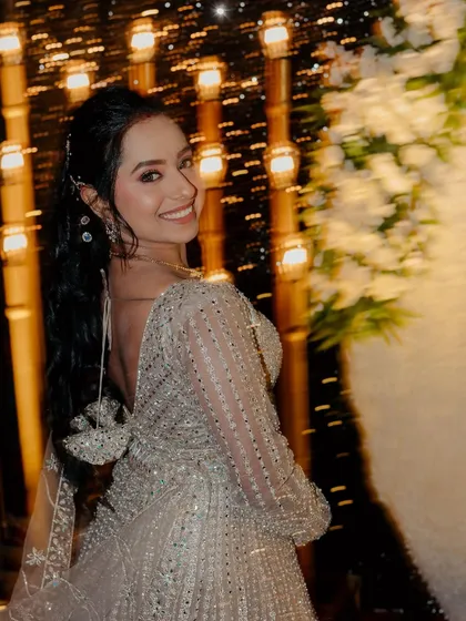 A playful, over-the-shoulder smile from the bride, showcasing her stylish ponytail.