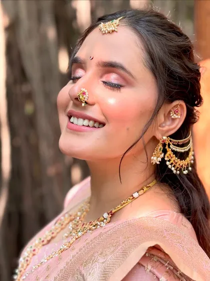 Eyes closed, she soaks in the moment. This shot beautifully displays the soft pink eyeshadow and the radiant highlighter on her cheekbones, capturing my signature 'flawless glow' finish.