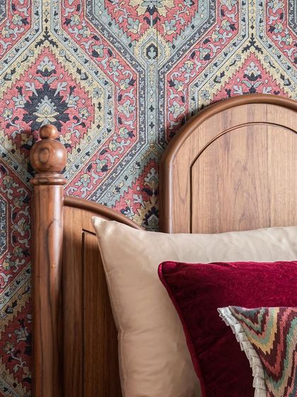 A close-up of the bold, patterned fabric that serves as a stunning headboard, bringing vibrant color and traditional motifs into the grandparents' bedroom.