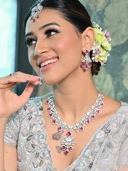 A joyful, smiling portrait that showcases the bride's happiness. The soft makeup and fresh floral bun create a look that is both modern and romantic.