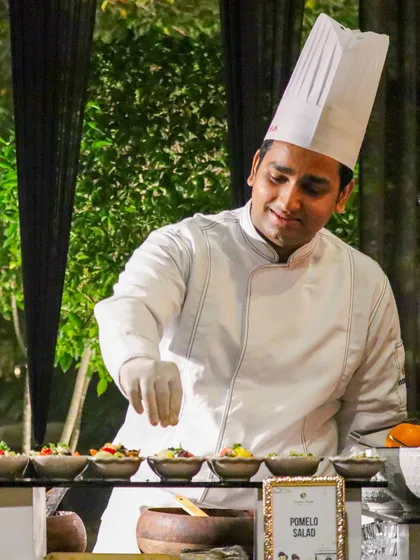 With a smile, our chef garnishes a line of Pomelo Salads, showcasing the joy and passion we put into our craft.