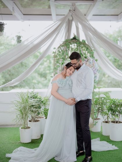 A heartwarming couple's maternity photo. The light blue gown complements the partner's attire perfectly, creating a cohesive and loving portrait.