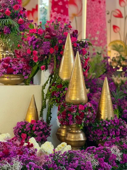 A close-up of the traditional golden decor pieces, nestled amongst a bed of vibrant purple and magenta flowers.