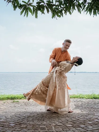 A romantic dip against the serene backwaters of Kerala, showcasing a beautiful destination wedding. I plan weddings not just in Bangalore, but also in stunning locales like Coorg, Mysore, and Kerala.