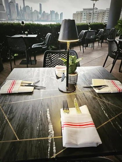 A close-up of the table setting on the LokalJC patio. The custom tabletop with brass inlays and elegant lighting shows our attention to detail in creating a complete design experience.