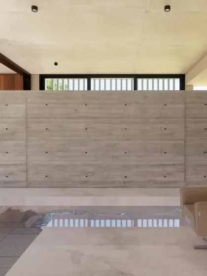 I prefer to let materials speak for themselves. This interior wall of exposed, board-formed concrete adds raw texture and character to the living space, contrasting with the smooth, polished flooring.