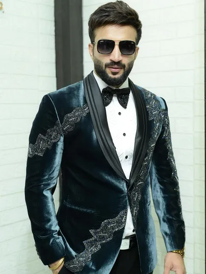 A direct look at the teal velvet tuxedo. The combination of the rich color, shawl lapel, and detailed embroidery makes this a true statement piece.