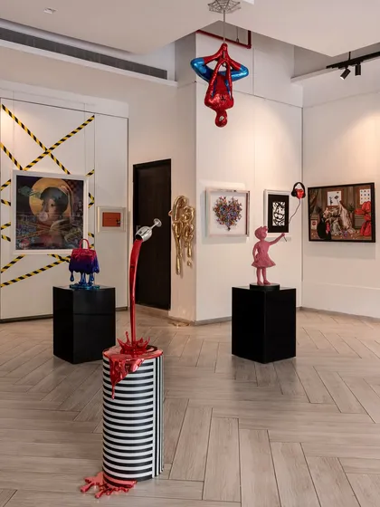 This isn’t your typical white-walled gallery. This view shows how we use the space to tell a story, with Spider-Man hanging from the ceiling above a curated collection of sculptures and paintings.