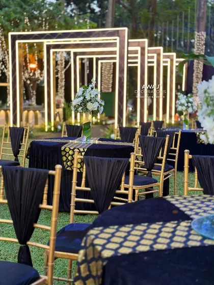 Guest seating at the Sangeet, with black and gold themed tables and chairs that complement the modern, edgy decor.
