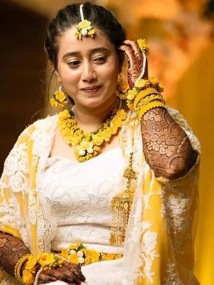 A beautiful portrait of the bride from her haldi ceremony, her yellow floral jewelry perfectly complementing her intricate mehndi.
