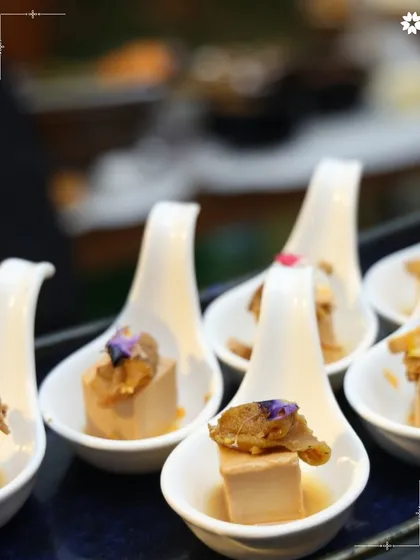 A single, perfect bite. This canapé, served in a ceramic spoon, combines textures and flavours in one elegant morsel, ideal for a sophisticated cocktail hour.