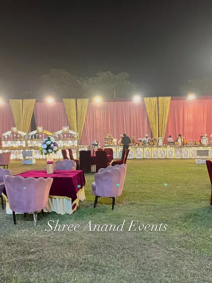 A view across the lawn showing different seating arrangements, from small tables to lounge areas, with the catering setup in the background.