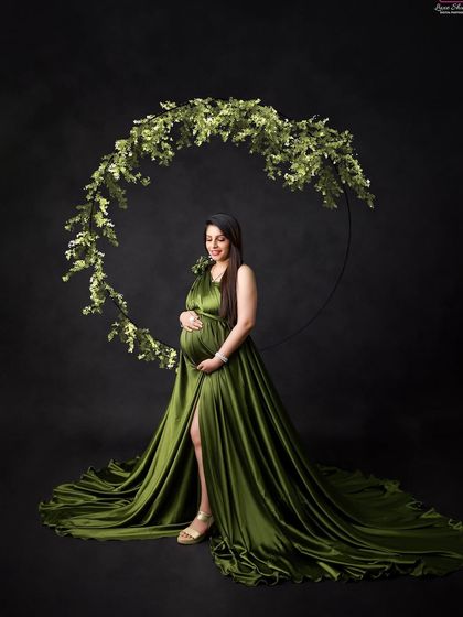 An olive green satin gown provides a look of earthy elegance. Paired with a simple greenery hoop, this portrait is both natural and sophisticated.