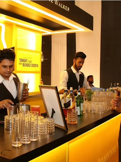 A bartender crafts cocktails at the branded bar. Professional execution and attention to detail ensure a premium experience for all guests at our brand activation events.