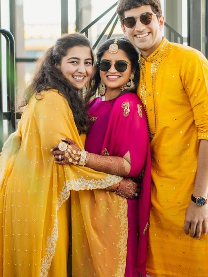 A happy moment between the siblings and the bride at the Haldi. Their coordinated yellow and pink outfits create a bright and joyful frame, perfectly capturing the spirit of the event.