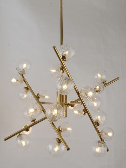 A classic sputnik chandelier with textured glass globes on a brass frame. This design offers a timeless modern look for any room.