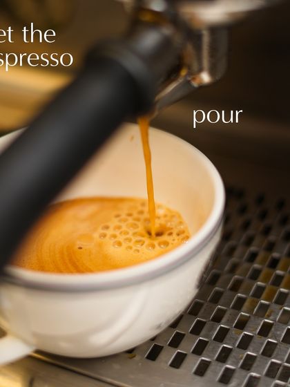 The first step to a great coffee is a perfect espresso shot. Here, the rich, aromatic espresso pours from the machine, forming a beautiful crema.
