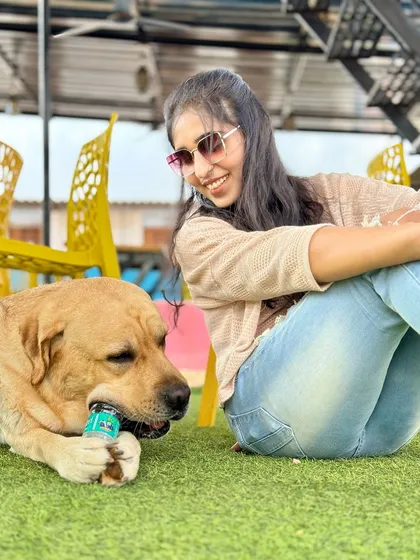 It's not just about the dogs. We've created comfortable, relaxing spaces for pet parents to unwind while their dogs play. Here's a happy moment captured on our astroturf lawn.