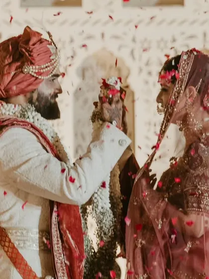 The groom lovingly places a flower in the bride's hair during the ceremony, a small, sweet gesture of affection.
