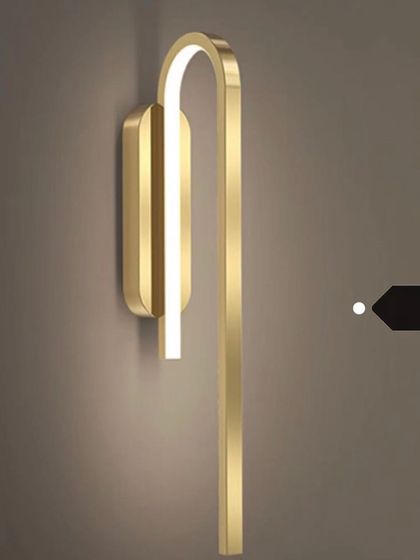 A minimalist, U-shaped wall sconce in a brushed gold finish. Its sleek and simple design is perfect for modern interiors.