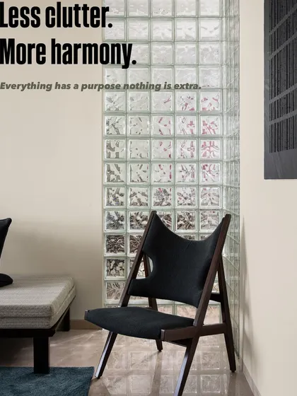 Less clutter, more harmony. This corner embodies our design principle that everything should have a purpose. The minimalist daybed and sculptural chair are perfectly balanced by the texture of the glass block wall.
