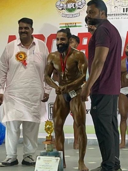 On stage at the NPC Rajasthan show, celebrating the gold medal win. My experience as NPC Delhi Head helps my athletes understand exactly what judges look for.