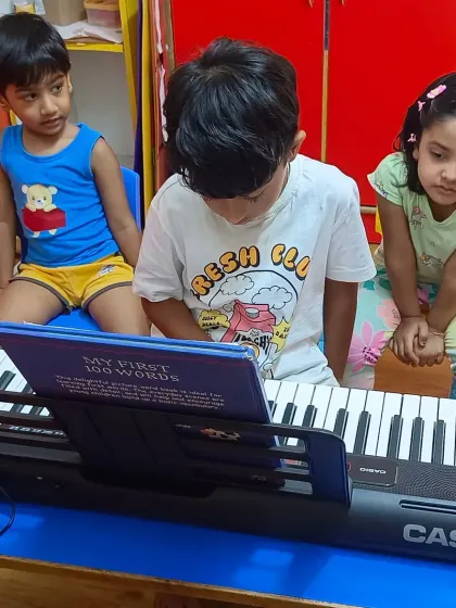 Curiosity in action. Kids at our summer camp gather around the piano, eager to learn their first notes and understand how music is made.