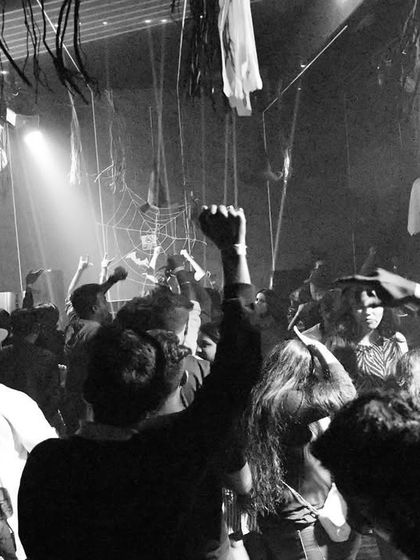 The crowd in Belgaum, captured in black and white. The raw energy and raised fists show a dance floor completely unified by the music.