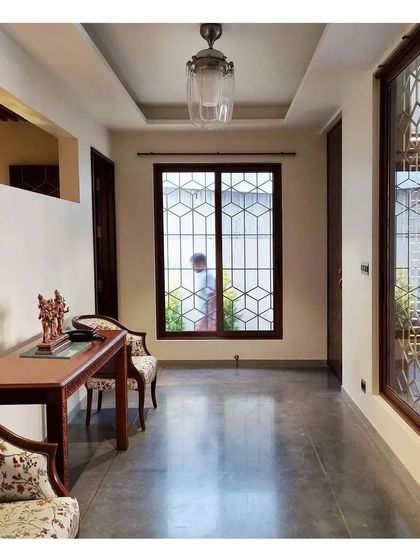 The geometric pattern from the main door is carried through to the window grills, creating a cohesive design language for the home's exterior.