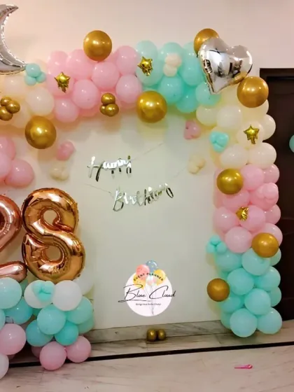 A pastel-themed wall decoration for a 28th birthday with foil numbers and moon and star accents.