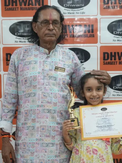 A senior guru with a young student and her award.