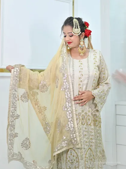 This elegant off-white sharara suit is a perfect example of our sophisticated wedding guest collection. It combines traditional embroidery with a modern silhouette, offering a comfortable yet stylish choice.